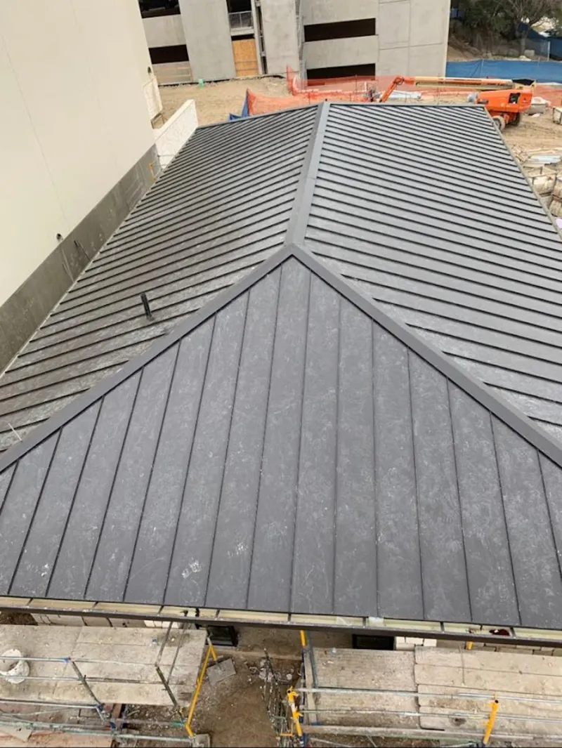 Commercial metal roof construction with crane equipment in Milpitas